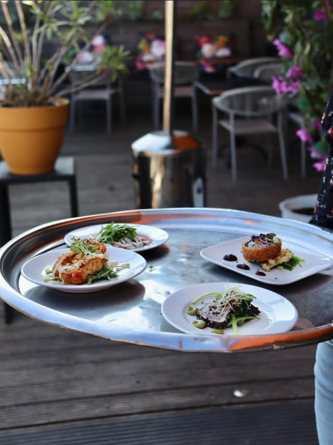 Medewerker brengt een dienblad met tapas naar tafel in restaurant Rodaen in Bunnik
