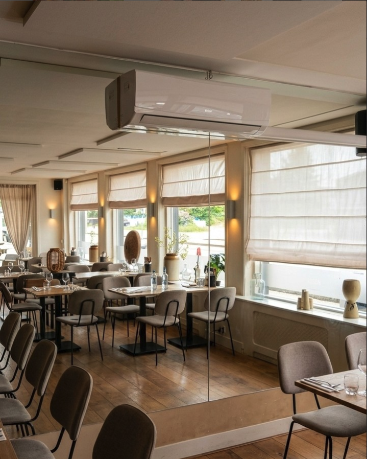 De lichte restaurantzaal van Rodaen in Bunnik met houten vloer, gedekte tafels en grote ramen