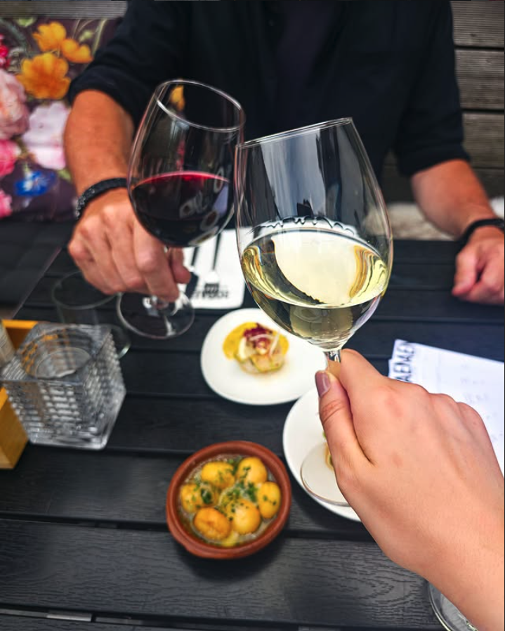 Gasten proosten met wijn aan tafel bij tapasrestaurant Rodaen in Bunnik