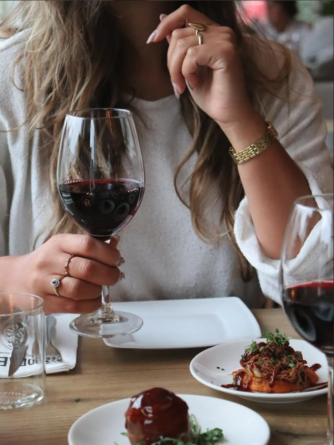 Gast met een glas wijn en een bord tapas bij Rodaen in Bunnik
